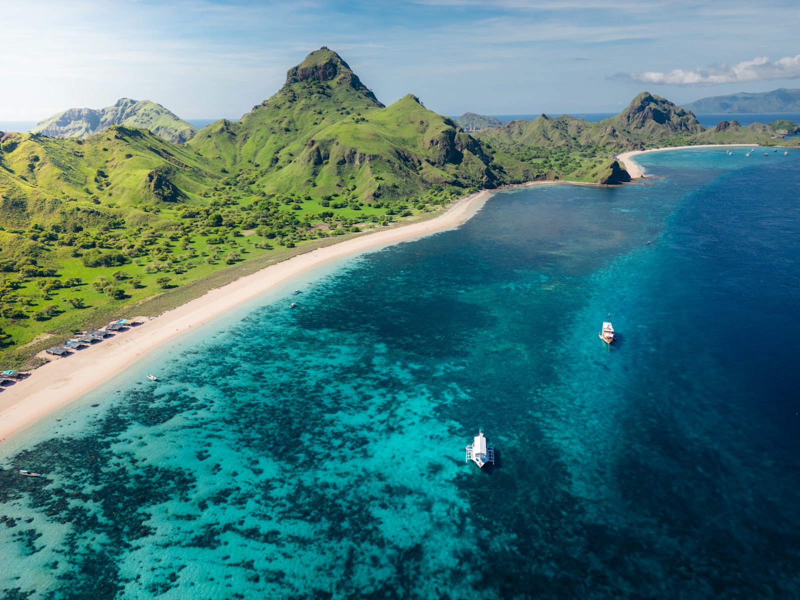 An aerial view of a tropical island with sailboats