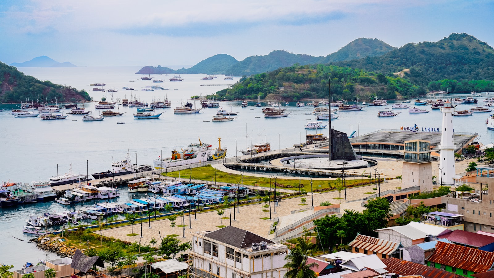 Boats docked in a bay with lush green hills.