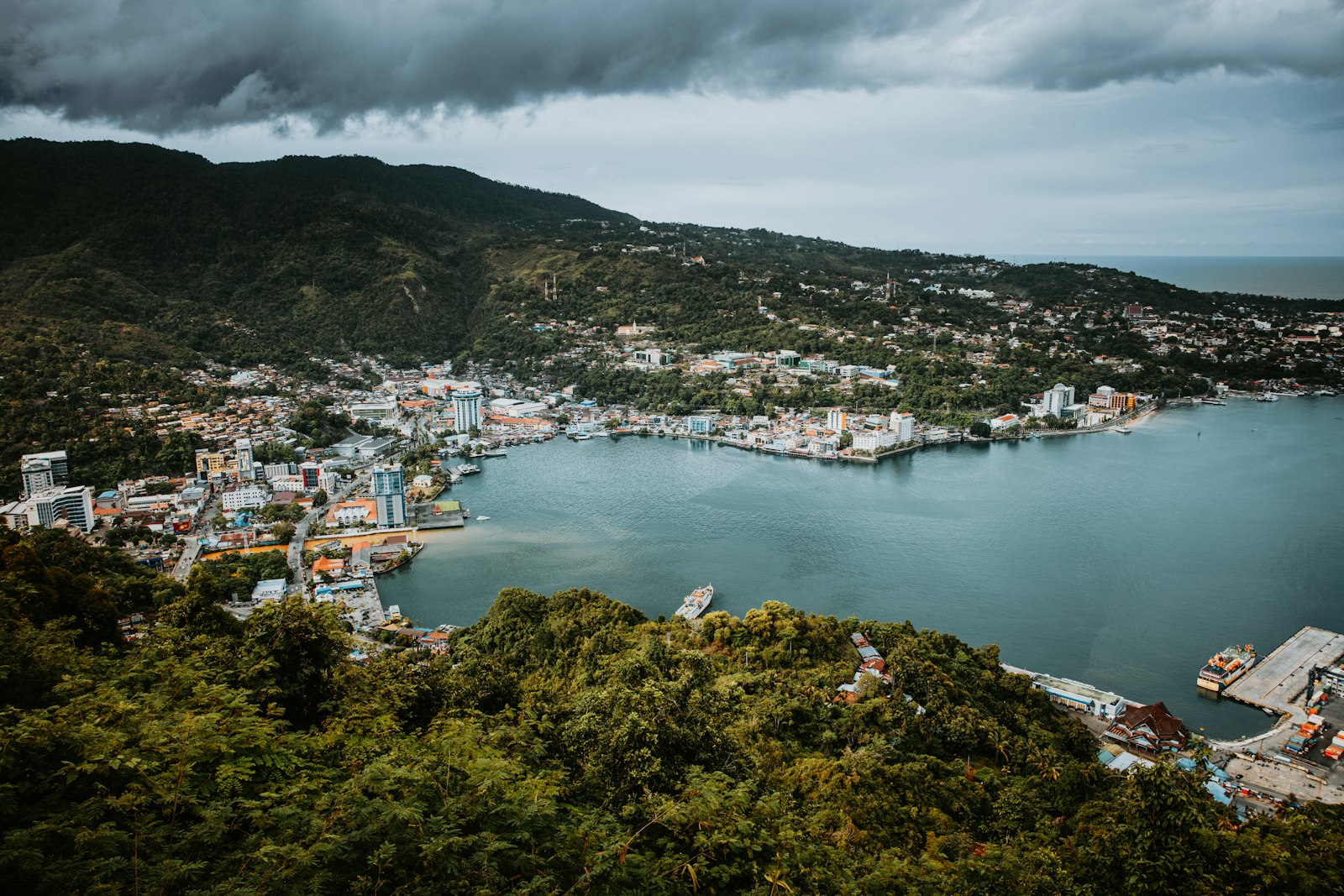 A large body of water surrounded by a lush green hillside